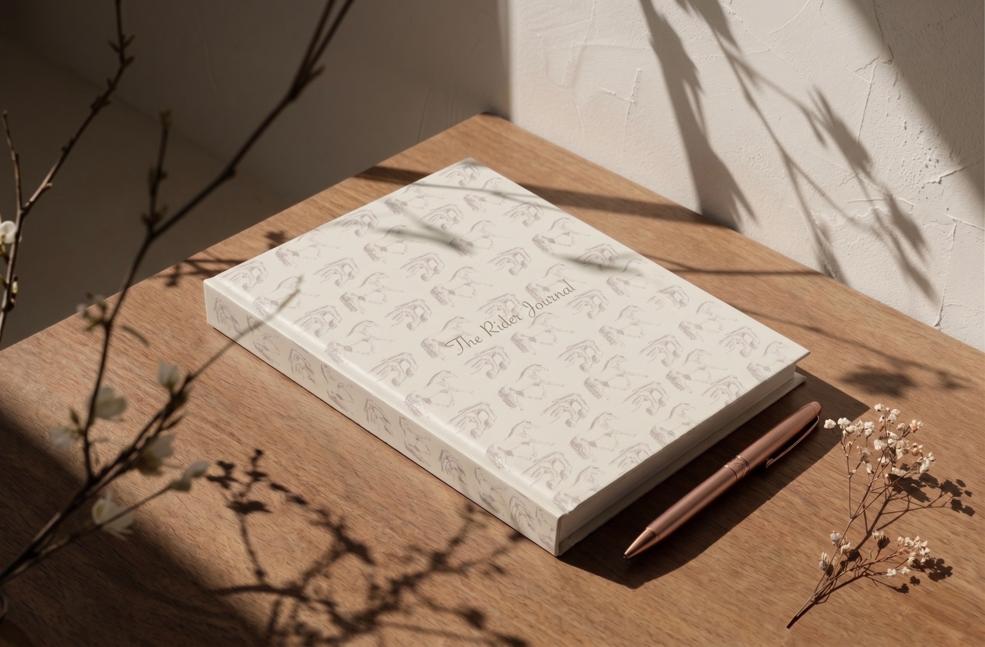 The Rider Journal, a horse-patterned journal for riders, with a rose gold pen